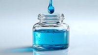 Vibrant blue liquid droplet falling into clear glass jar containing turquoise solution against light background, showcasing liquid dynamics.