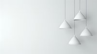 Minimalist white pendant lamps hanging at different heights against light gray wall background, creating modern interior lighting design composition.