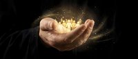 Open hand releasing golden light particles and sparks against dark background, representing success, magic, energy, and innovation for business and technology concepts.