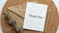 Thank you card with kraft envelope, wooden pencil, and eucalyptus on cork board, eco-friendly stationery for gratitude and appreciation.