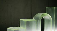 Translucent glass geometric shapes arranged in ascending order on dark concrete background, showcasing modern minimalist design and architectural aesthetics.