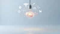 Glowing light bulb with brain inside surrounded by floating innovation icons representing creative thinking and business ideas for startup concepts.