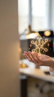 Woman's hand holding glowing golden snowflake hologram with sparkles in modern home interior with warm lighting and blurred background, suitable for holiday marketing and seasonal campaigns.
