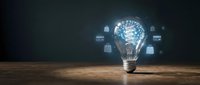 Glowing light bulb with digital brain circuit pattern and floating data icons on wooden surface against dark background for innovation concepts.