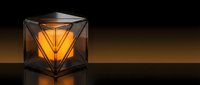 Geometric glass lantern with warm glowing filament inside, casting golden light against dark background. Modern decorative lighting fixture for interior design and home decor projects.