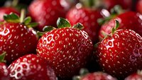 Fresh ripe strawberries with green leaves and water droplets, ideal for food, nutrition, healthy eating, and culinary design projects.