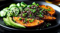 Grilled salmon fillet with black quinoa, cucumber salad and avocado slices on dark plate. Healthy protein-rich meal with superfoods and fresh vegetables.