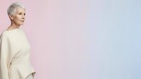 Senior woman with short white hair wearing cream-colored sweater, standing in profile against soft pink and blue gradient background for lifestyle and wellness content.