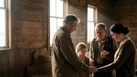 Multigenerational Caucasian family holding hands in prayer inside a rustic wooden cabin, expressing faith, unity, and togetherness.