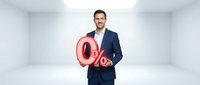 Male professional in dark business suit holding glowing red percentage symbol in modern white office space, representing discount, sale, interest rate, financial growth, and business promotion concepts.