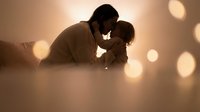 Romantic couple sharing intimate moment with warm bokeh lights creating dreamy atmosphere for love and relationship concepts.