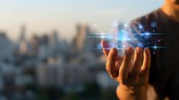 Businessman holding glowing digital hologram with network connections and data visualization against blurred cityscape background for technology and innovation concepts.