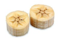 Fresh sliced banana pieces showing cross section with natural star pattern on white isolated background, ready for healthy eating and food design.