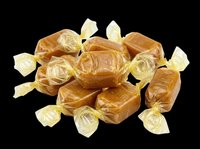 Pile of caramel candies wrapped in golden and clear cellophane, isolated on transparent background. Ready for design use on packaging, posters, clipart, and print-on-demand products.