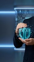 Businessman in dark suit holding glowing digital shield icon with circuit board patterns, representing cybersecurity, data protection, and network security solutions for enterprise technology.