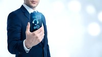 Professional businessman in dark suit holding smartphone with digital CO2 carbon footprint tracking app interface on screen for environmental monitoring.