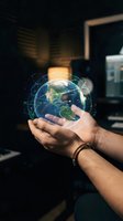 Hands holding holographic Earth globe with digital network connections in modern office environment for global business and technology concepts.