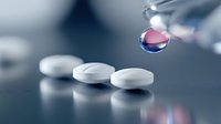 Liquid medicine drop falling onto white pharmaceutical tablets on dark surface with soft focus and dramatic lighting, demonstrating medical treatment concept.