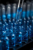 Laboratory pipette dispensing blue liquid into test tubes for scientific research and chemical analysis in modern lab setting.