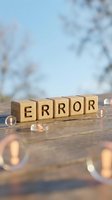 Wooden blocks spelling error message on wet surface with blurred winter background and bokeh lights, representing mistake, failure, and problem-solving concepts.