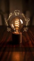 Vintage Edison bulb with glowing culinary icons including chef hat, utensils and herbs creating warm atmospheric lighting for restaurant branding and food concepts.