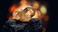 Raw citrine crystal specimen on dark volcanic rock with warm golden bokeh lights creating mystical mineral display for healing and meditation practices.