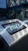 Futuristic digital tablet displaying 2027 with glowing wave effects on metallic surface in modern tech environment for business presentations.
