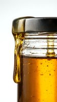 Closeup of golden beer in glass mug with metal handle and lid, showing carbonation bubbles and condensation, isolated on white background for beverage advertising and packaging design.