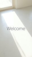 Bright minimalist interior with sunlight streaming through a window onto a white floor, featuring the word Welcome for greeting designs.