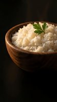 Steamed white rice in wooden bowl garnished with fresh parsley on dark background for culinary and restaurant menu design.
