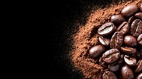 Fresh roasted coffee beans scattered next to ground coffee powder on dark background, dramatic side lighting creates contrast between whole beans and fine powder.