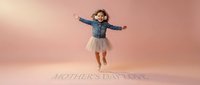 Happy young girl jumping with arms spread wide on pink background with Mother's Day Love text for greeting cards and family celebrations.