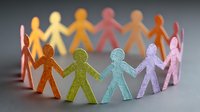Colorful paper cutout figures holding hands in circle formation, symbolizing unity, diversity, teamwork, and community connection.