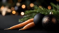 Black and copper Christmas ornament with fresh carrots and pine branch against dark background with golden bokeh lights creating festive winter mood.