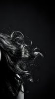 Dynamic flowing hair in motion against black background capturing movement and texture in monochrome artistic style for beauty and fashion concepts.