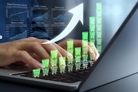 Businessman hands typing on laptop with digital shopping cart icons and financial growth charts showing e-commerce sales analytics and revenue increase.