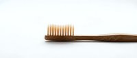 Eco-friendly bamboo toothbrush with natural bristles on white background for sustainable oral hygiene and zero waste lifestyle products.