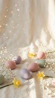 Pastel colored Easter eggs with spring flowers and baby's breath on soft fabric background with warm bokeh lights for holiday celebration and decoration.