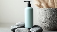 Minimalist spa composition with white pump bottle on natural stones against neutral background, wellness and skincare concept for beauty products.