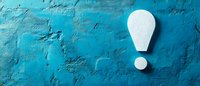 White exclamation mark on textured turquoise blue concrete wall background with copy space. Creative concept for attention, warning and important notice.