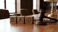 Wooden blocks with legal symbols including courthouse, gavel and scales of justice on lawyer desk with judge gavel for law firm branding materials.