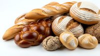 Fresh artisan bread collection with baguettes, sourdough loaves, braided challah and crusty rolls isolated on white background for bakery marketing.