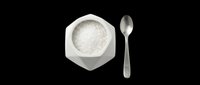Hexagonal white ceramic bowl filled with sea salt crystals next to a metal measuring spoon, isolated on transparent background. Ready for culinary, cooking, and food design projects, t-shirts, clipart, and print-on-demand products.
