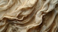 Crumpled beige fabric with soft folds and wrinkles creating abstract organic texture pattern, dramatic shadows and light interplay for luxury design background.