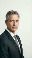 Middle-aged male professional with gray hair wearing dark business suit and tie, isolated on white background for corporate portraits and business applications.