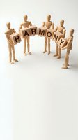 Wooden mannequins holding letter blocks spelling harmony arranged in circle on white background, representing teamwork, unity, cooperation and collaborative business success.
