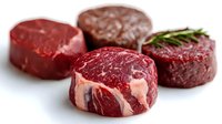 Raw beef steaks with marbling on white background, fresh red meat cuts for grilling and cooking, butcher shop quality protein for culinary preparation.