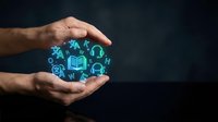 Adult male hands with medium skin tone cradling glowing blue digital education icons including books, graduation caps, and learning symbols against dark background for online learning concepts.