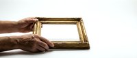 Elderly hands holding ornate golden picture frame against white background, concept for memories, family photos, heritage and framing artwork.