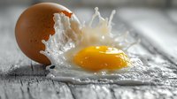 Cracked brown egg with bright yellow yolk and white splashing on rustic wooden surface, dramatic food photography with selective focus and motion capture.